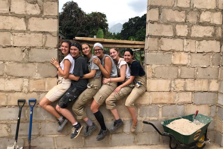 Schüler sitzen auf Mauer